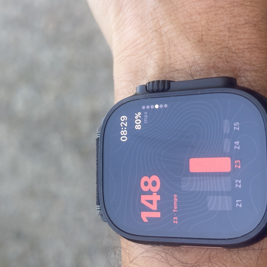 The watch showing heart rate 148 in zone 3 against the session's tempo target, with a Z1 to Z5 bar